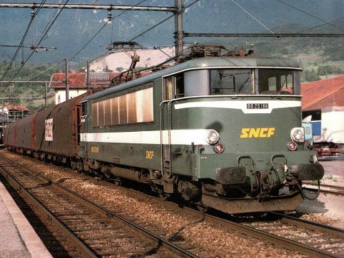 Septembre 1983 : un train complet de wagons plats à bâchage mécanique passe à Bellegarde tracté par la BB 25188.